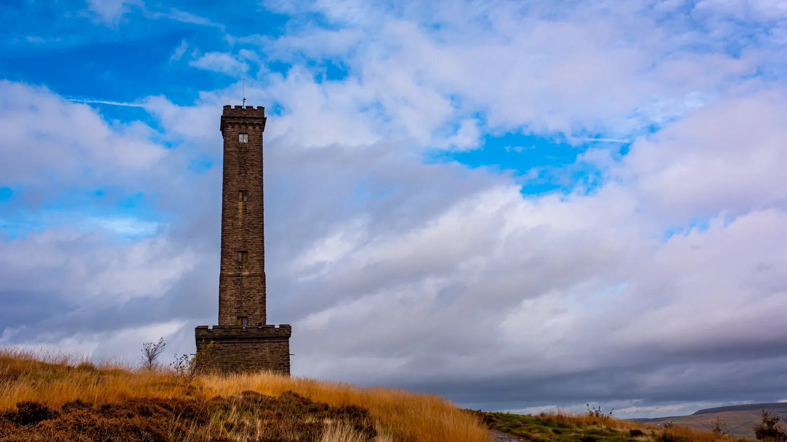 The Peel Monument on Holcombe Hill under a blue and white sky