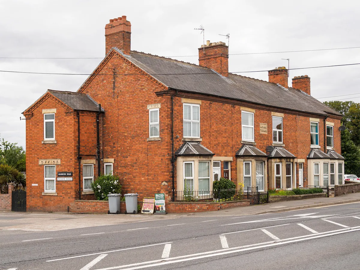 A row of Victorian red-brick terraced houses with bay windows on Midland Terrace in Newark