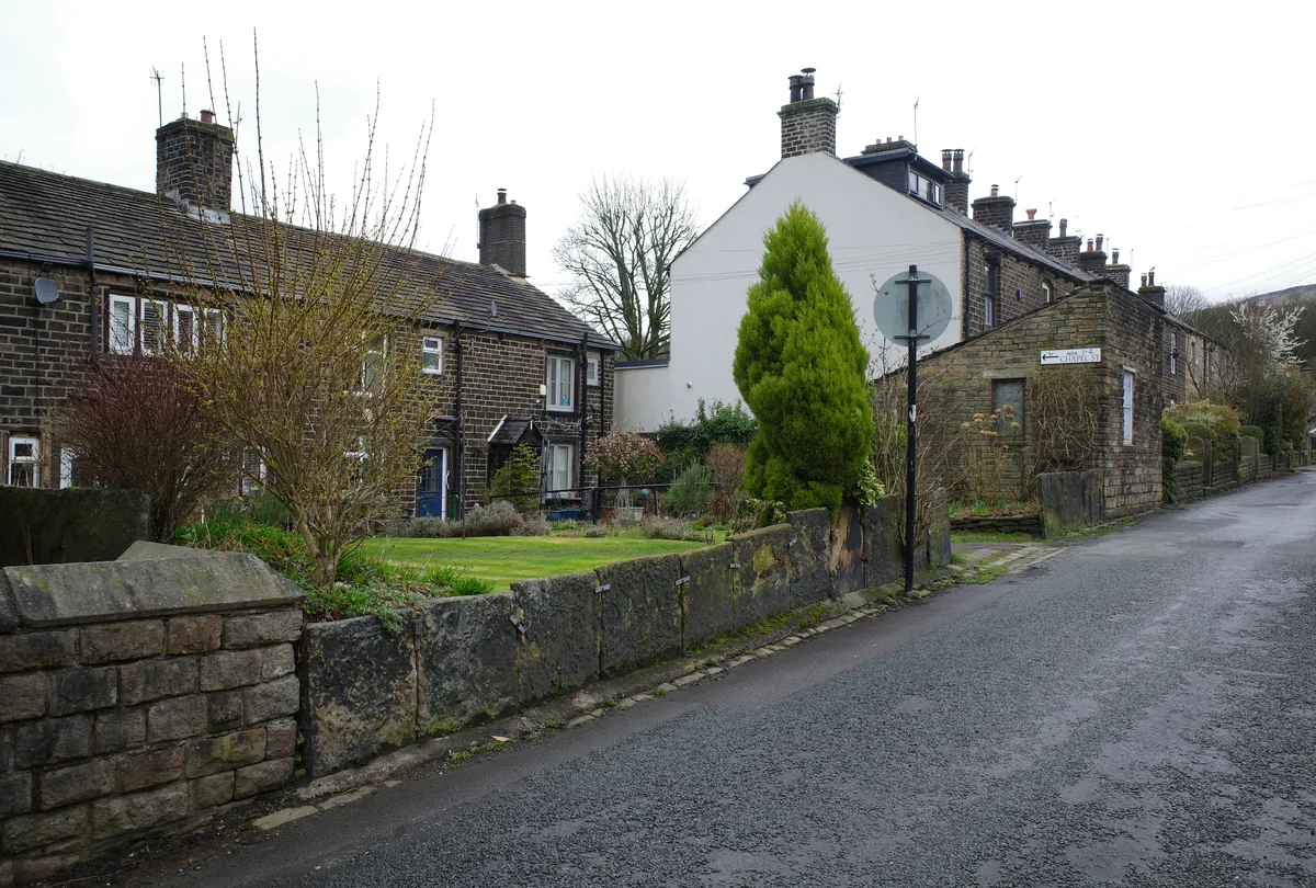 Gritstone cottages with front gardens on Church Road, Uppermill