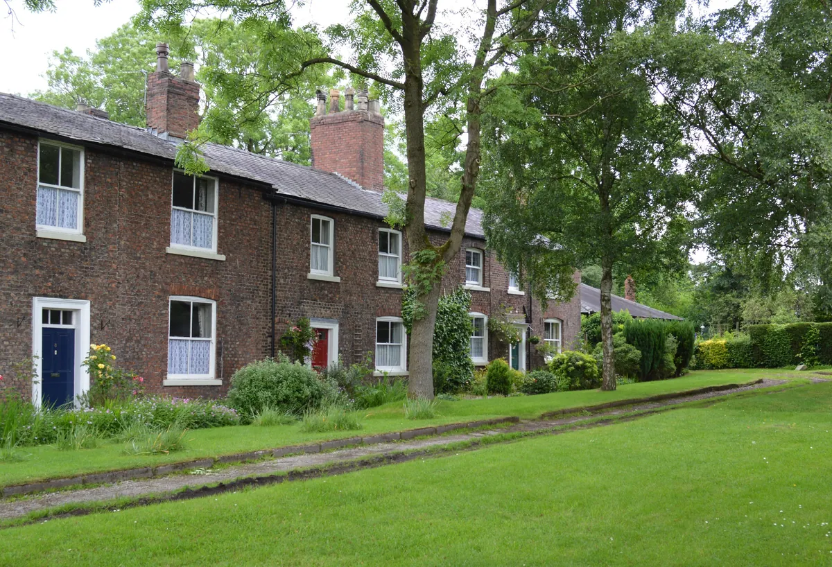 Georgian brick cottages facing a lawn at Fairfield Moravian Settlement in Droylsden