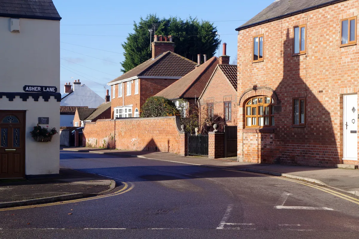 Red-brick houses and garden walls where Distillery Street meets Asher Lane in Ruddington