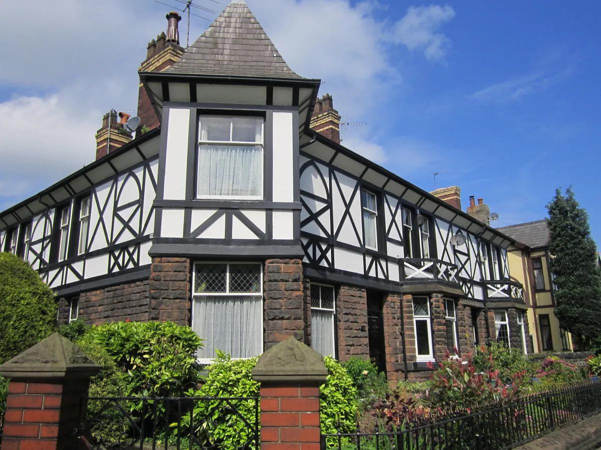 Black-and-white mock Tudor houses behind front gardens on Wigan Road in Ashton-in-Makerfield